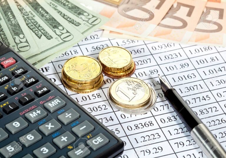 calculadora con billetes y monedas sobre mesa