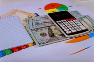calculadora y billetes junto a documentos financieros