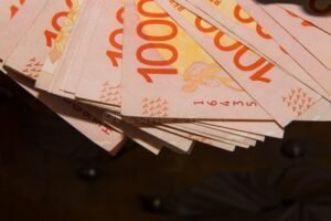 factura y moneda argentina sobre mesa madera