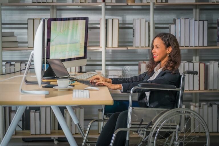 persona con discapacidad usando computadora y documentos financieros