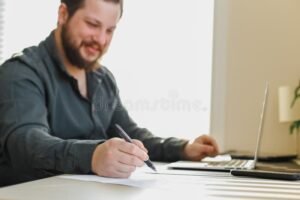 persona escribiendo carta de renuncia oficina