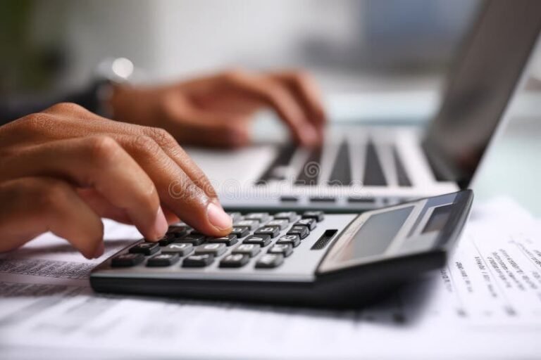 persona usando computadora y calculadora oficina