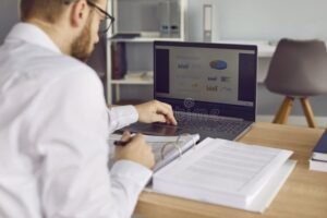 persona usando computadora y documentos financieros 1