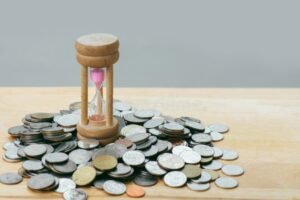 reloj de arena con monedas apiladas